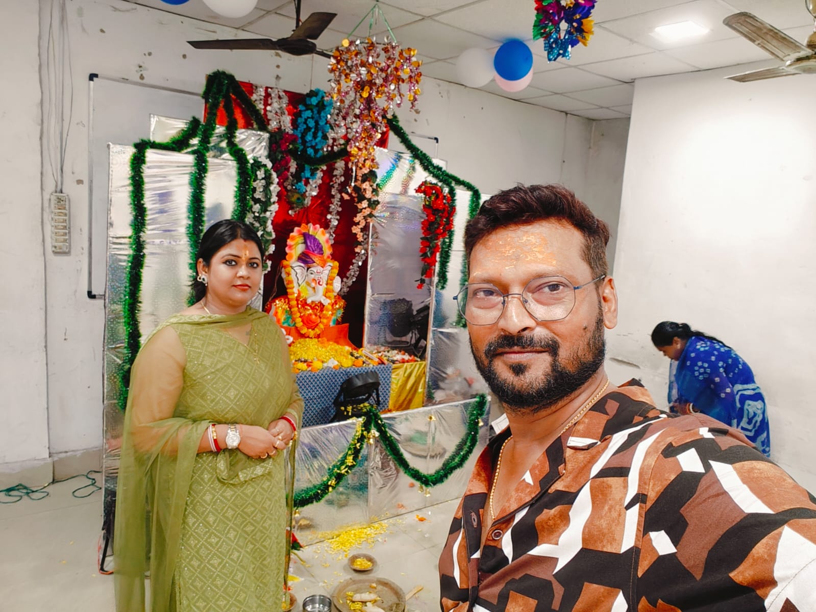 Teachers standing in front of Ganesh shrine during puja